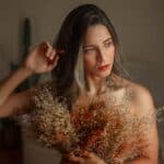 High-quality image of a young woman holding a bouquet of dried flowers, perfect for branding and commercial use.