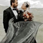 Romantic wedding photo capturing the bride and groom gazing at each other with a mountainous backdrop.